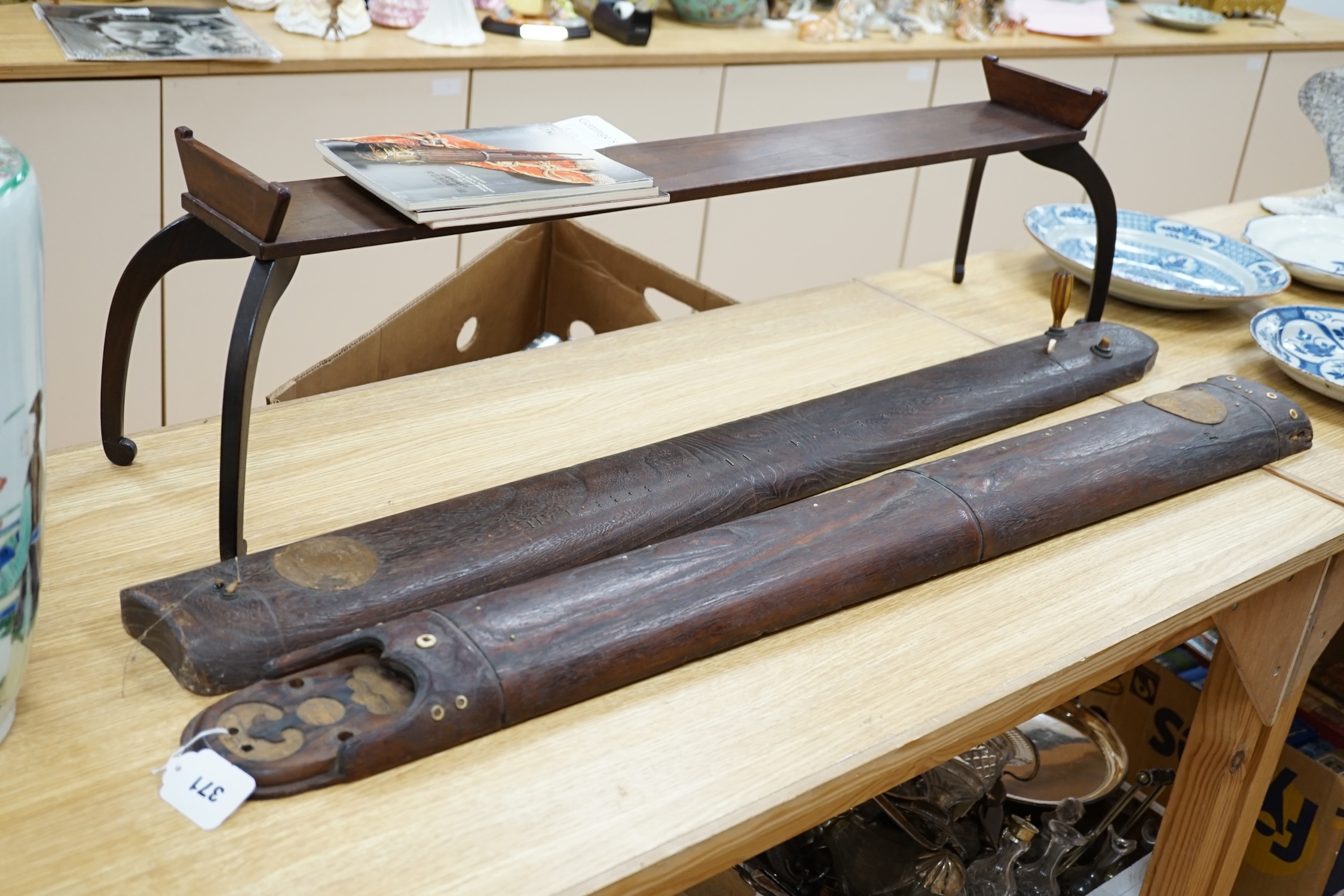 Two Japanese musical instruments and a stand, together with three catalogues, instruments 108cm long